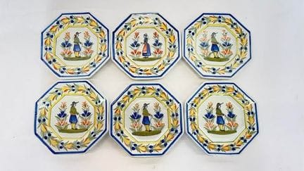 HENRIOT 产自坎佩尔。六只八角形多色釉陶甜点盘，饰有布列塔尼风情图案。直径：18 厘米。