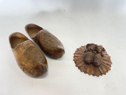 Une paire de sabots en bois sculpté à décor d'un c