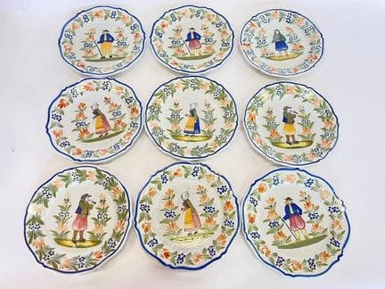 HENRIOT 产自坎佩尔。一套9只陶盘，饰有布列塔尼人图案和花环。20世纪作品。直径：29.5厘米