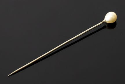 A 750‰ white gold tie pin set with a pearl. Eagle-