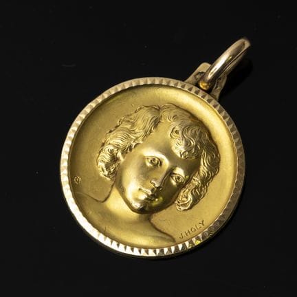 J. HOLY. A 750‰ yellow gold medal depicting a chil