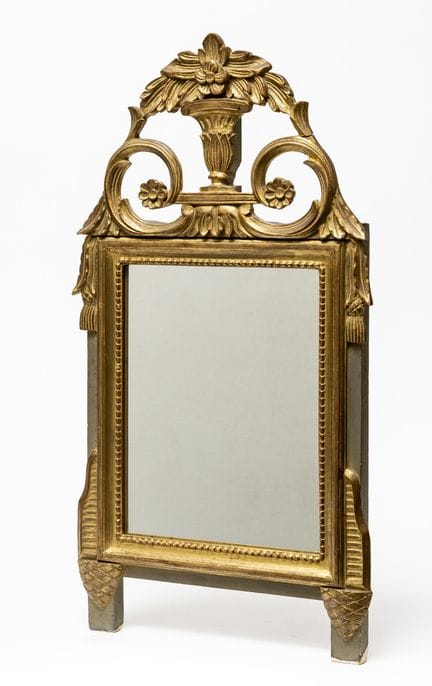 A small carved and gilded wooden mirror, with a pe