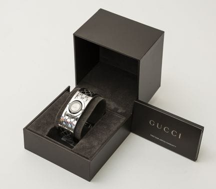 GUCCI。一款Twirl系列女士腕表，采用不锈钢材质，圆形可翻转表壳，表圈镶嵌明亮式切割钻石，石英