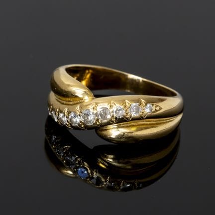 A 750‰ gold ring set with a row of diamonds weighi