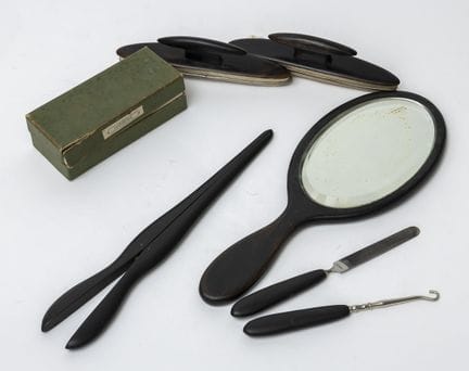 A blackened-wood toiletries set consisting of a ha
