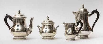 一套950‰纯银茶具及咖啡具，配木质手柄，包含咖啡壶、茶壶、奶壶及带盖糖罐。饰有月桂叶卷纹和珠饰带纹