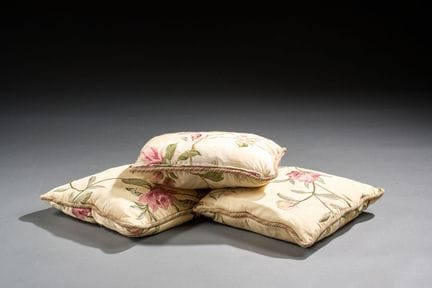 Set of three cushions made of cream-colored fabric