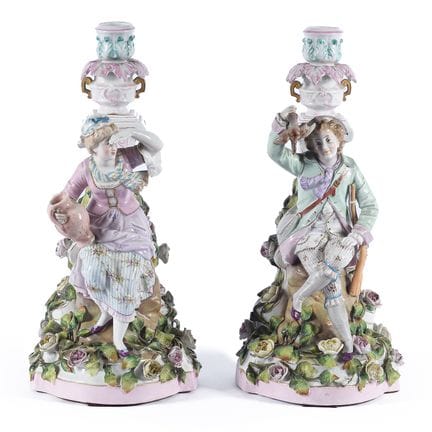A pair of porcelain candlesticks depicting figures