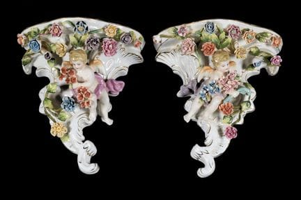 Pair of porcelain wall sconces depicting cherubs. 