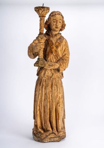 Escultura de madera que representa a un ángel sost