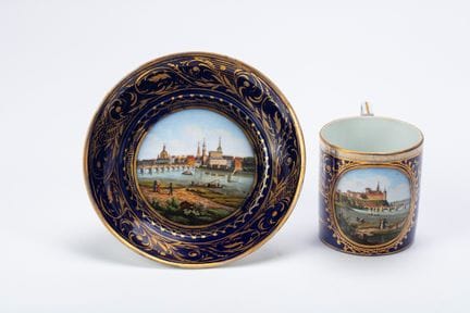 A polychrome porcelain cup and saucer with views o