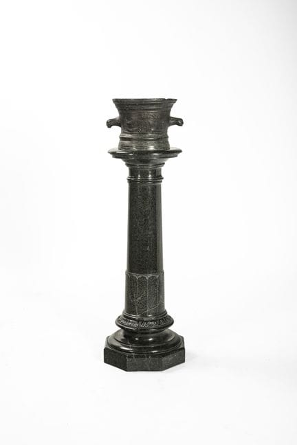 Antiguo mortero de bronce con dos asas sobre una c
