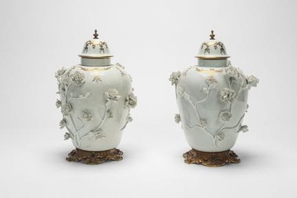 Two white and gold porcelain vases decorated in re