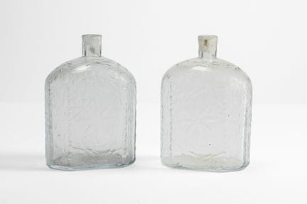 Un par de botellas de cristal tallado con motivos 