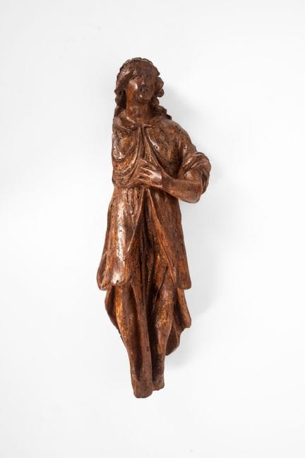 Friso de madera tallada que representa a un santo.