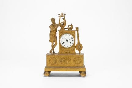 A gilt bronze pendulum clock surmounted by Apollo.