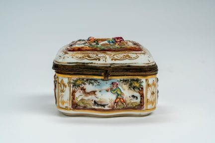 Caja con tapa de porcelana policromada en relieve.