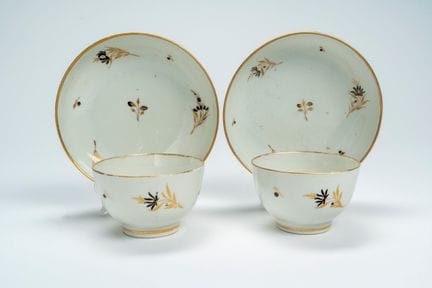 A pair of porcelain cups and saucers decorated in 
