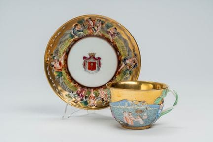 Una taza y un platillo de porcelana con un escudo 