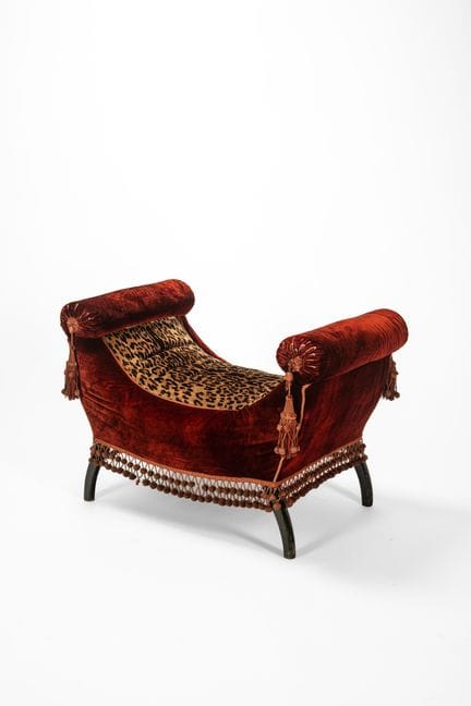 Seat with padded armrests upholstered in red velve