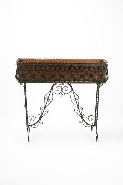 Wrought-iron flower box with scrolls and a copper 