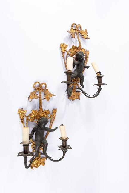A pair of two-light wall sconces in gilded and pat