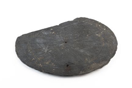 A slate sundial engraved with geometric patterns a