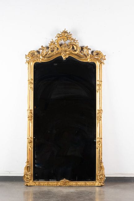 Large beveled mirror with a wooden frame featuring