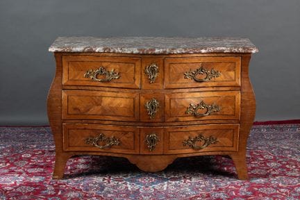 A curved chest of drawers with a rounded front and