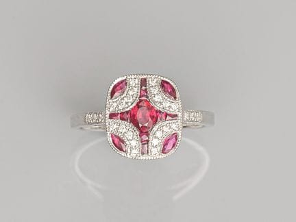 Platinum cushion-cut ring, set with an oval ruby, 
