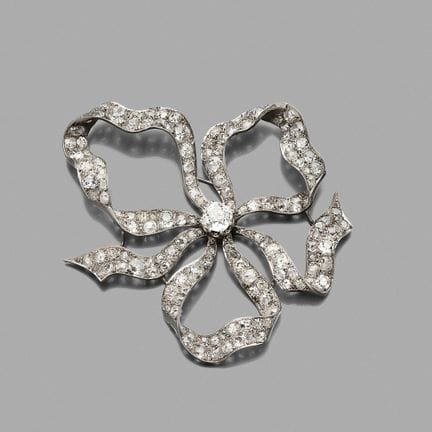 Broche 
en or gris 18K (750) dessinant des rubans 
