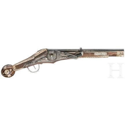 A wheellock pistol, collector's replica in the sty