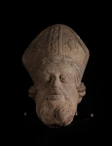 Tête d'évêque de style roman, XIIIe-XIVe siècle.

