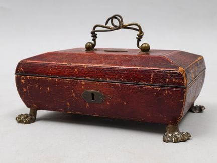 Estuche rectangular revestido de cuero rojo, con a