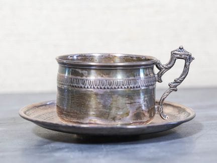Silbertasse und Untertasse mit einem Fries aus Her