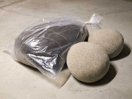 Three "Livingstones" pebble-shaped wool cushions