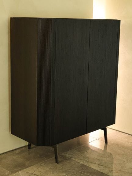 Mueble de madera ranurada con dos puertas que dan 
