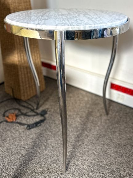 Mesita de tres patas, con base curvada de metal y 
