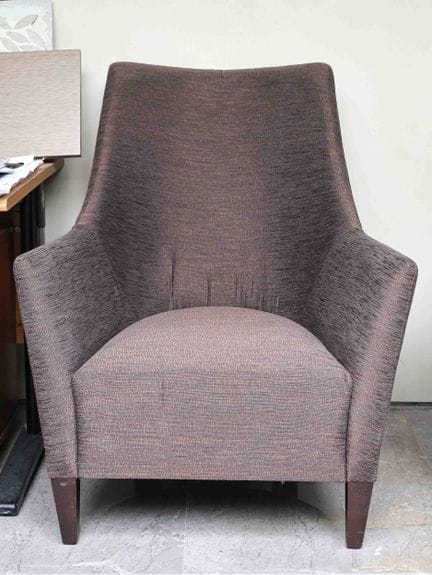 A comfortable armchair with a wooden base and moir