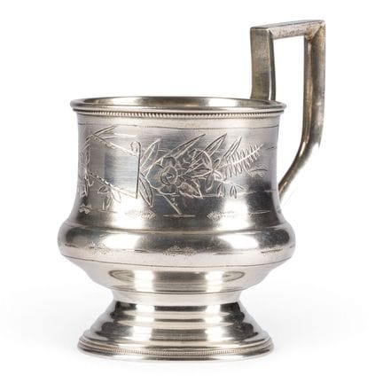 A SILVER TEA-GLASS HOLDER WITH ENGRAVED DECORATION