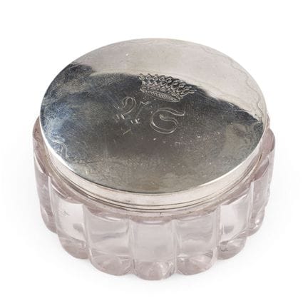 UNA CAJA DE POLVO DE CRISTAL CON TAPA DE PLATA DE 