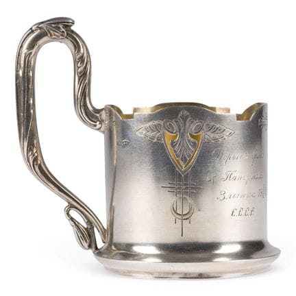 A SILVER TEA-GLASS HOLDER WITH ENGRAVED DECORATION