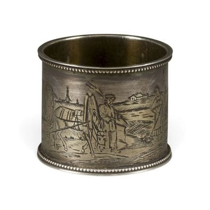A SILVER PARCEL-GILT NAPKIN HOLDER WITH PEASANTS L