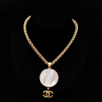 CHANEL
Collier en métal doré orné d'un pendentif d