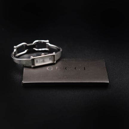 GUCCI 
Montre bracelet rigide en métal gris, cadra