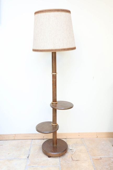 Un lampadaire en bois à deux petites étagères circ