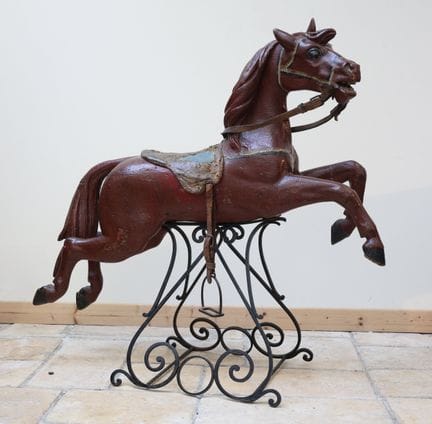 Un cheval de carrousel en bois peint, la selle et 