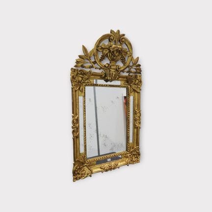 Miroir mural comportant un cadre en bois sculpté d