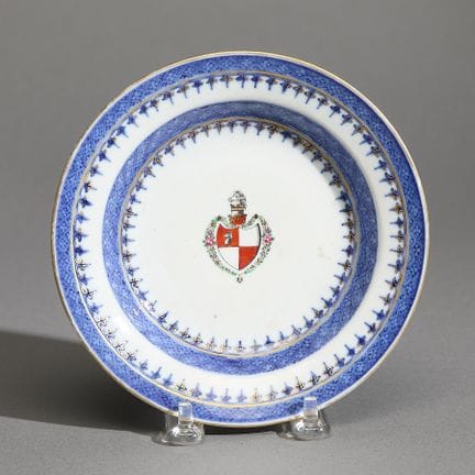 中国外销青花纹章瓷甜点盘或布丁盘，乾隆时期，约1780年。盘心饰有英国纹章，上方缀以马首纹章饰。盘底