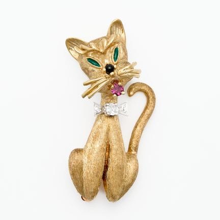 丹·弗雷尔（Dan Frere），美国。14k黄金猫形胸针，配以白金镶钻领结，口中镶嵌一颗红宝石。采